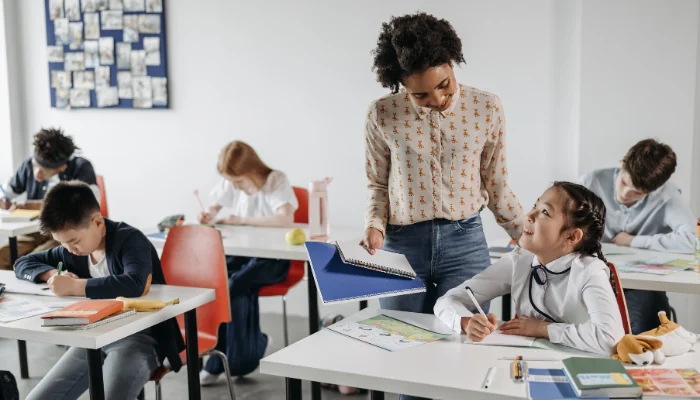 Como escolher o melhor plano de saúde para professores representado por uma professora em sala de aula.