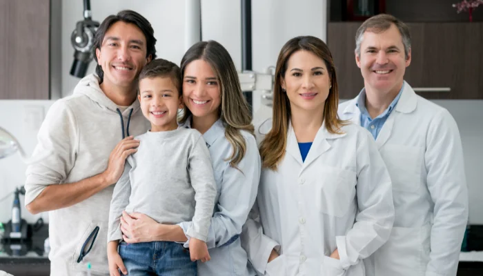 Qual o Plano de Saúde Mais Barato em Feira de Santana representado por uma família e dois médicos sorrindo.