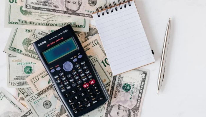 Valores dos Planos de Saúde em Campinas representado por uma calculadora, dinheiro e um bloco de notas.