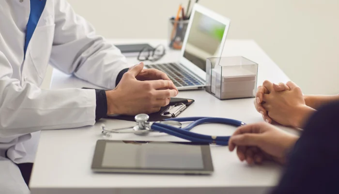 Quais os direitos do consumidor em relação à carência representado por um doutor explicando algo a dois pacientes.
