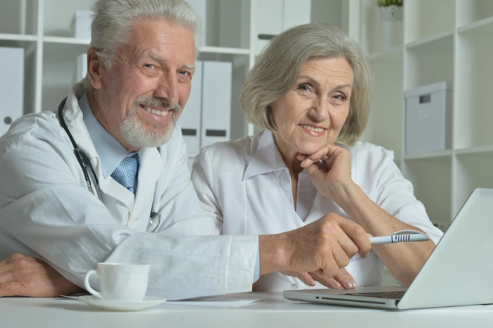 Médico explica plano de saúde para idosos acima de 80 anos para mulher idosa.