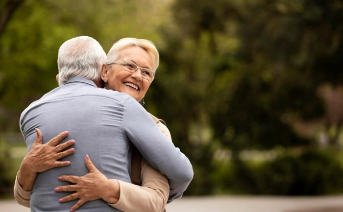Abraço feliz de casal de idosos, representando reajuste de plano de saúde para idosos.