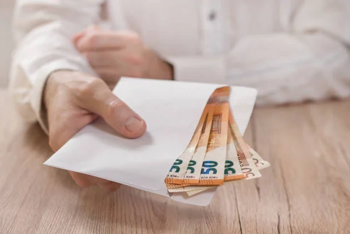 Pessoa segura envelope com notas de euro. Explicando como pedir reembolso sulamérica saúde após cirurgia.
